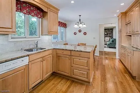 Kitchen with a table for informal dining, through the door a partial view of the den.