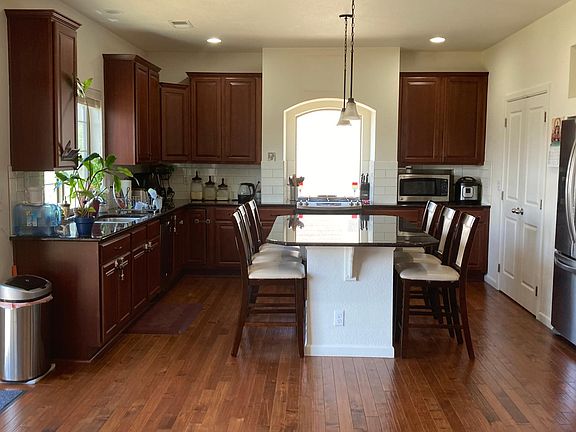 Kitchen with hardwood flooring, Granite counters, center island and 42'' cabinets.