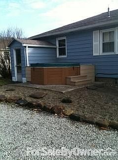Back of house an hot tub with deck