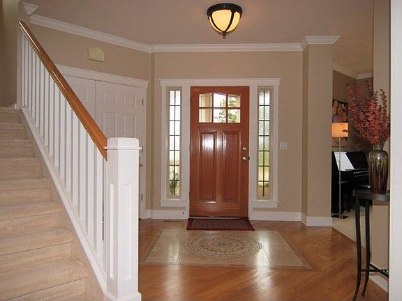 Spacious foyer features hardwood floors with tile inlay & vaulted ceilings