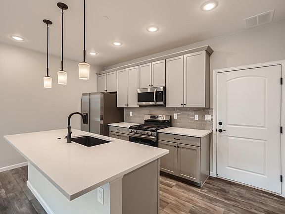 Kitchen with Quartz Countertops, Stainless Steel Appliances and a separate Pantry