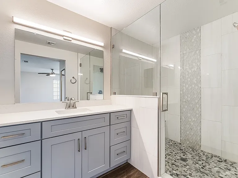 Beautiful new Primary Bathroom with Designer Tiles, large bench at rear, niche for shower products, full frameless glass surround, new vanity with quartz counters and polished chrome faucets, large mirror and LED lighting