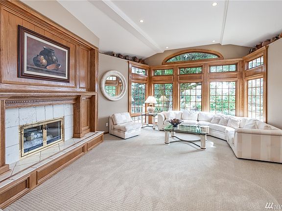 Formal living room has beautiful gas fireplace, custom wood trim, bright windows