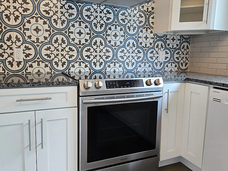 Kitchen with electric range and wall-mount-hood and tiled backsplash (to ceiling)