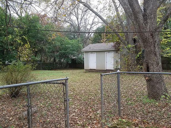 Fenced yard with dedicated storage unit.