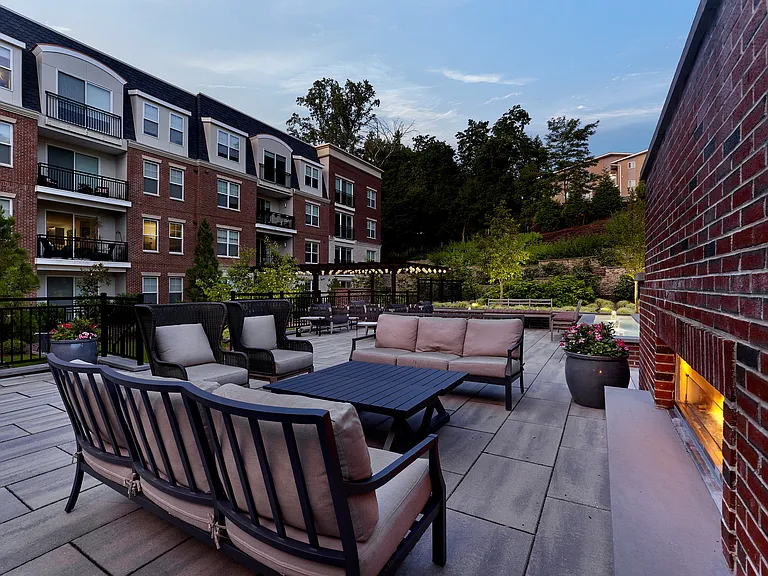 Chic outdoor lounge area with elegant seating and scenic views, surrounded by lush greenery and modern architecture.