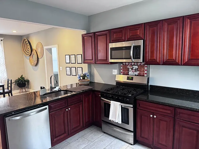 Well-appointed kitchen with ample cabinet storage, black countertops, and stainless steel range, microwave, and dishwasher.