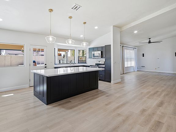 Kitchen and dining view looking over at large living room with vaulted ceilings throughout. Open floorplan.