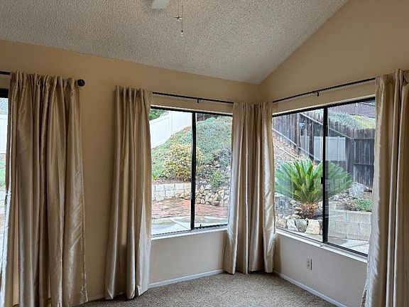 Dining area, vaulted ceiling with ceiling fan. Large windows looking out to back yard