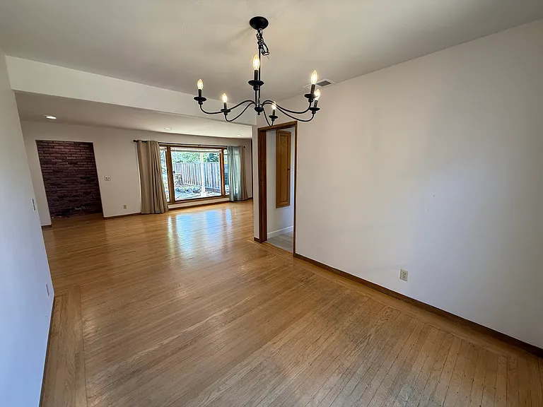 Bright, airy living room features bay window, hardwood flooring throughout.