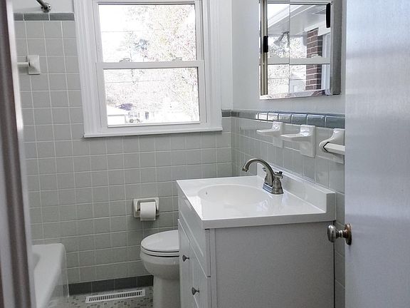 Hall bath - gray tones. New vanity, light fixture, faucet and toilet.