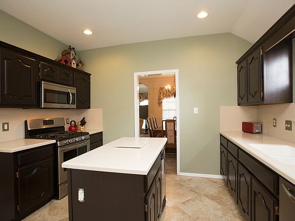 Spacious Kitchen is loaded with updates including solid surface counters, tile flooring, stainless steel appliances and refinished cabinets.