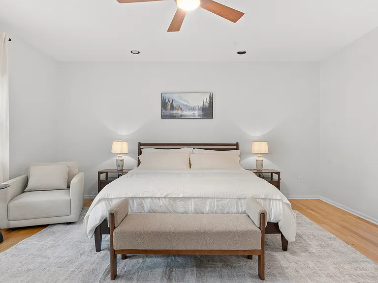 Primary bedroom with a comfortable reading chair, generous closet space, and private ensuite bathroom.