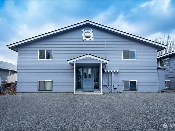 The back entrance and parking for 5 cars. area to the east of building with a shared bike rack and 4 and a storage shed for bikes or personal items that can be locked.>