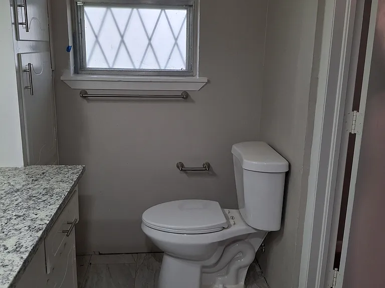 Reverse view of master bath. Linen storage cabinet to left by window.