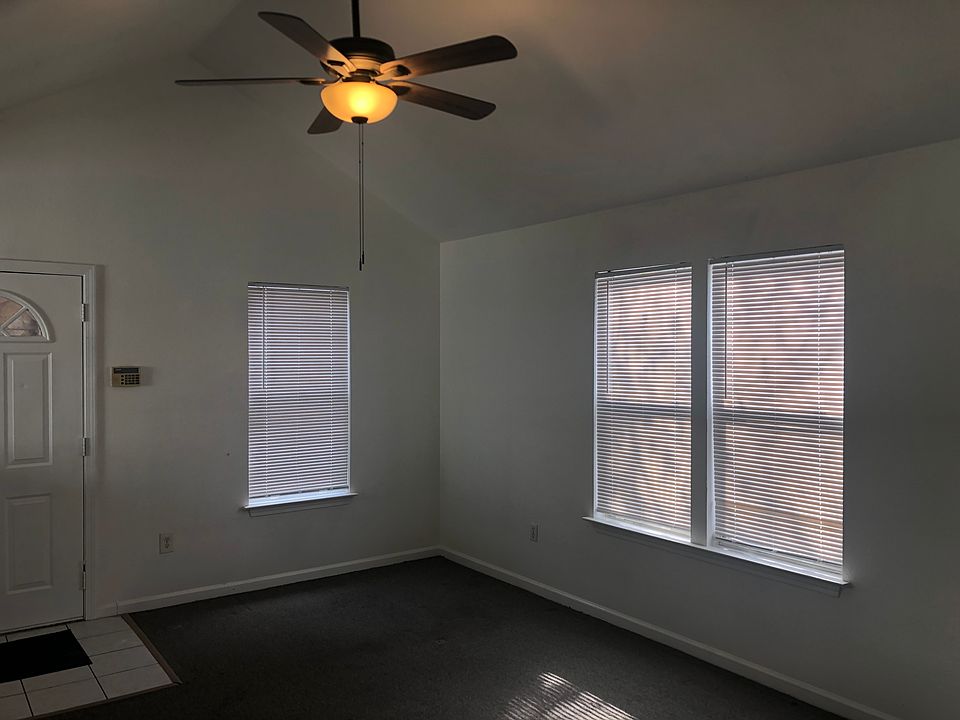 Spacious living area with vaulted ceilings and ceiling fan