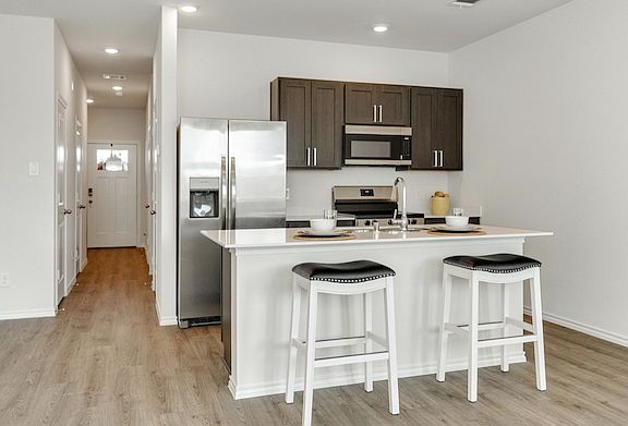 Stunning kitchen with a spacious breakfast bar, modern cabinetry and sleek finishes!