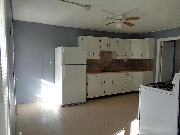 Sunny Eat-in-Kitchen with lots of cabinets! Modern counter and backsplash.