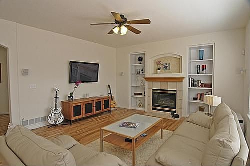 Living room with built-in shelves and gas fireplace.