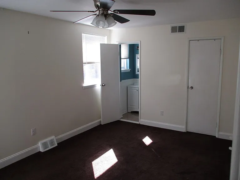 Master Bedroom with lighted ceiling fan. Small Bathroom to the left & Walk in Closet to the right.