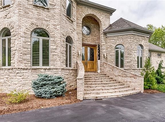 Brick and stone exterior lead to the grand entrance.