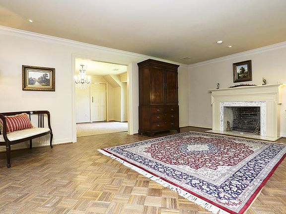 Formal living room features one of two fireplaces with wood mantel and stone surround. Opens to dini