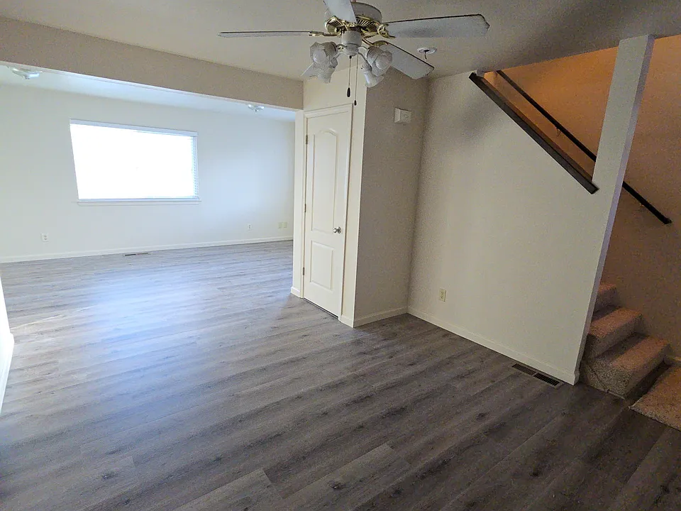 First floor great room with ceiling fan.
