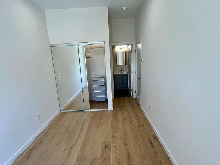 Master Bedroom with built-in Elfa closet system and private bathroom. A sliding glass door leads to the backyard