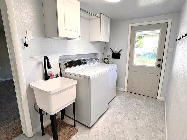 Laundry room with washer, dryer, and convenient utility sink
