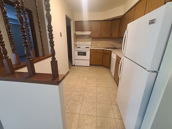 Open kitchen includes stove, fridge and dishwasher. Vent above the stove. Plenty of kitchen storage.