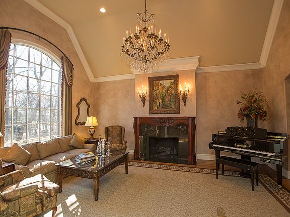 Formal Living Room with vaulted ceiling, granite surround fireplace, palladium window and hand-finished walls.