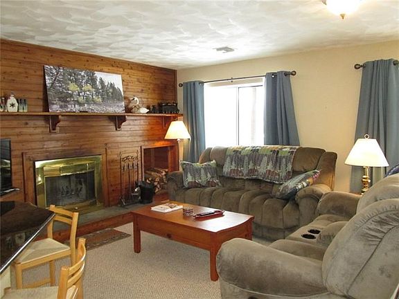 Note the built in wood storage bin to the right of the fireplace. Furnishings and accessories are included!
