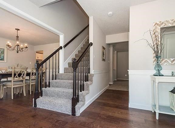 Beautiful hand scraped hardwood flows from the entry through the Dining Room to the Kitchen and Breakfast Room beyond. The stairs lead to the upper level. The stair system and rails have been finished in a current Java Ebony coloration. The Entry offers a
