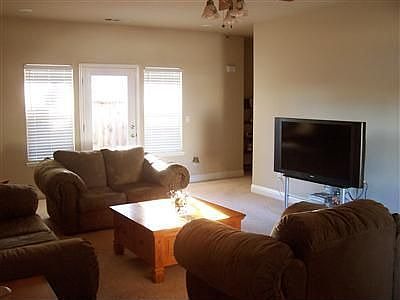 Very spacious living room with plush carpet and plenty natural sunlight.