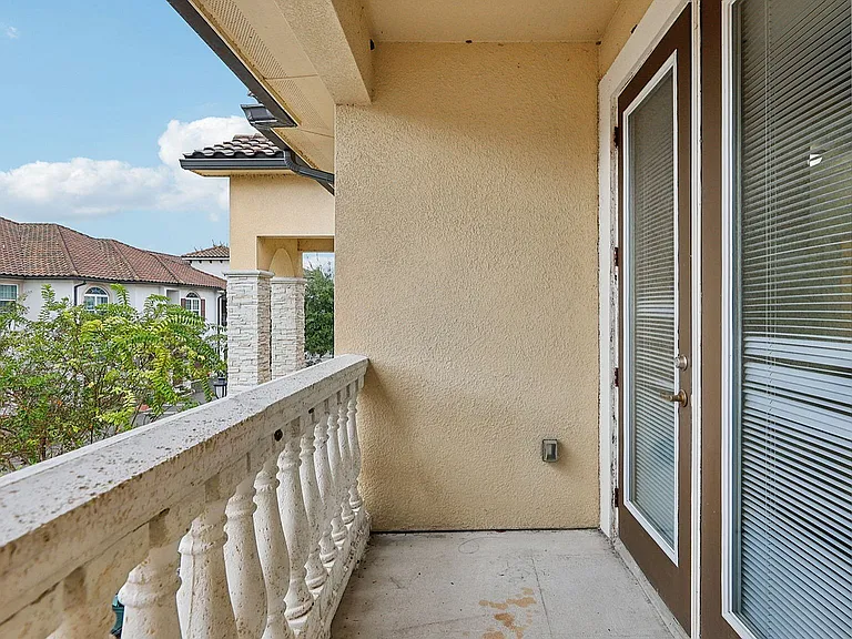 Charming balcony with elegant railing offering a scenic view and abundant natural light, ideal for relaxation.