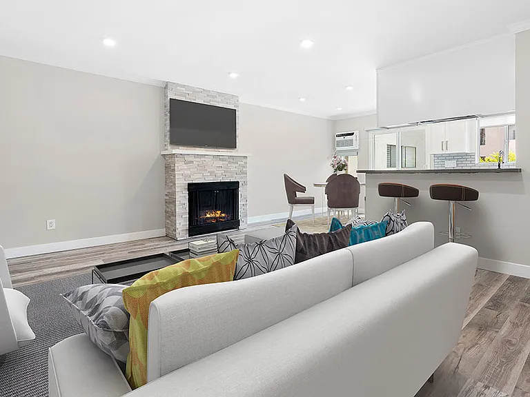 Hardwood floored living room with stone accented fireplace.
