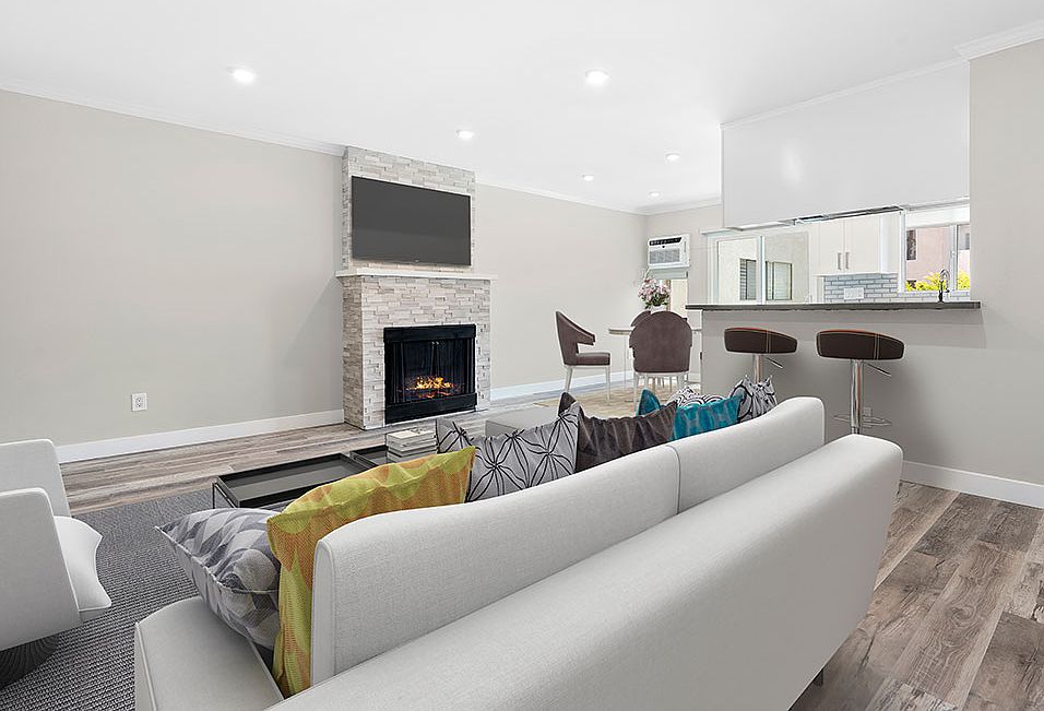 Hardwood floored living room with stone accented fireplace.