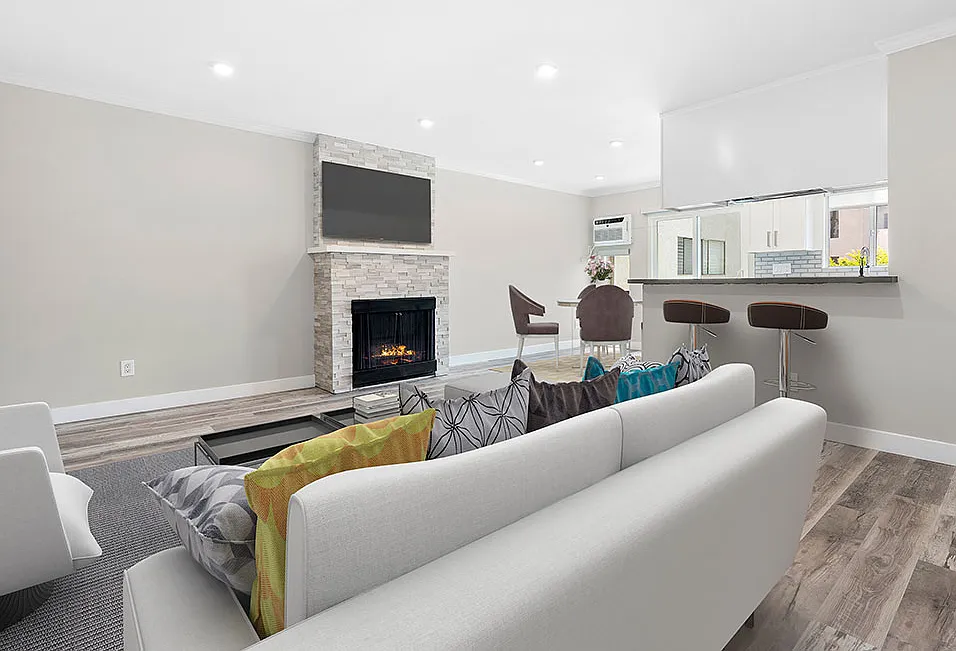 Hardwood floored living room with stone accented fireplace.
