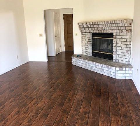 Corner fireplace in family room with raised hearh. All nuetral walls and window coverings.