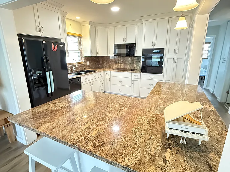 Updated kitchen with fridge, dishwasher, oven, cooktop and microwave. Breakfast bar.