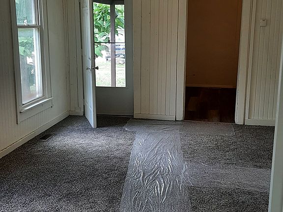 View from living room, looking through dining room to back door which is on north side of home, on 12th Street, and leads to fenced backyard. Open doorway is into kitchen area.