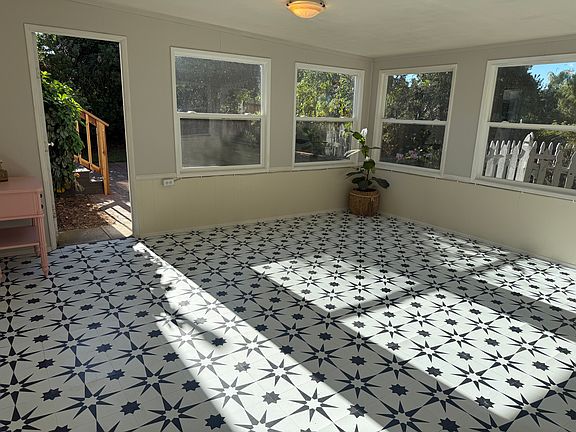 Sunroom: flex space with a convertible single mattress/seat. Garden views on three sides, opens to patio.