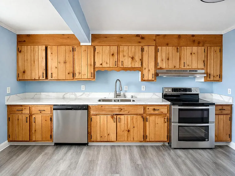 Kitchen with fridge, dishwasher and oven.