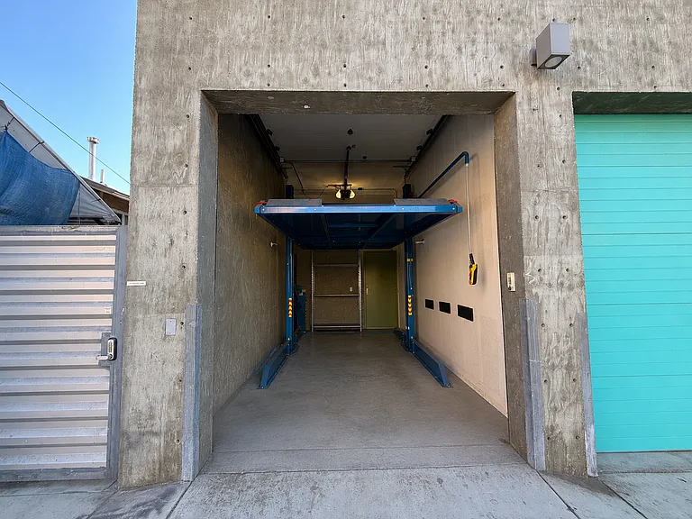 Garage with a commercial grade hydraulic car lift. Use the upper deck for another SUV or storage
