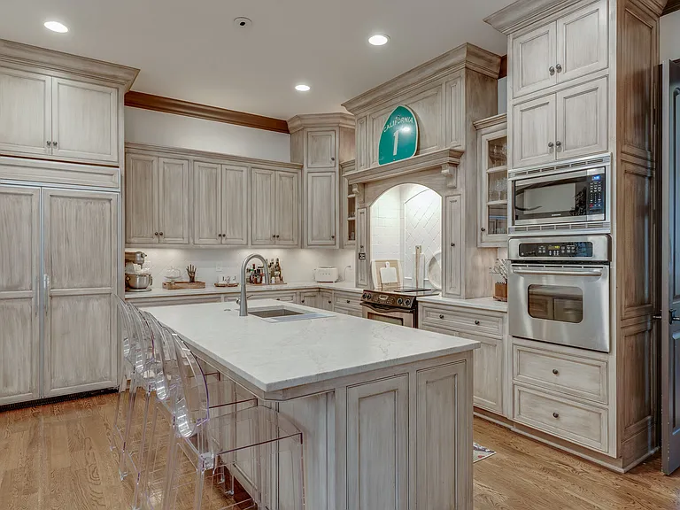 Kitchen 2 ovens, jenn air cooktop, microwave, Bosch dishwasher, built-in side by side refrigerator, island seats 4, custom cabinetry and storage