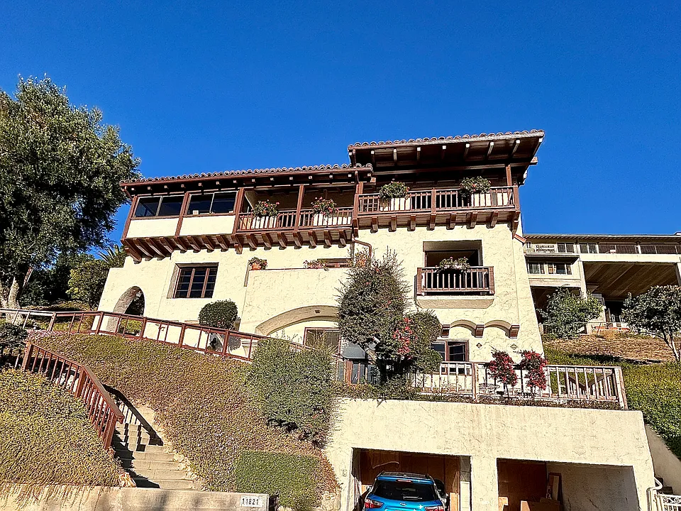 You'll use the brown gate to the left of the garage. (White gate on right is for the tenants of the 2 studio units on right side of home.) Neither garage space is included with this unit.