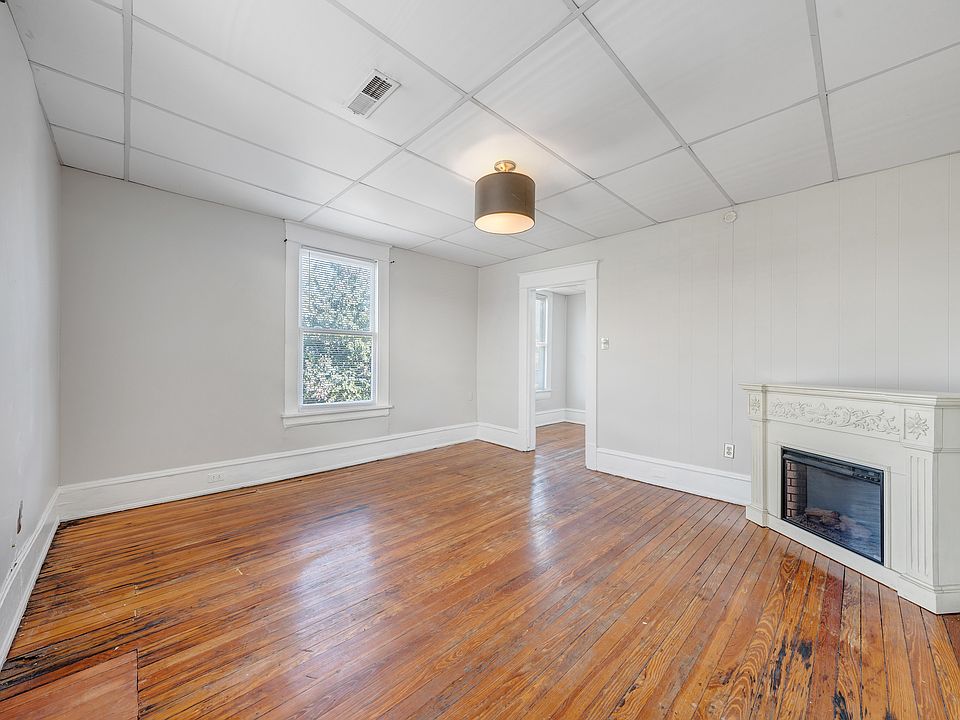 Spacious Living Room with Original Harwood Floors, Designer Lighting, Electric Fireplace and New Sherwin Williams Ammonite Gray Paint Throughout.