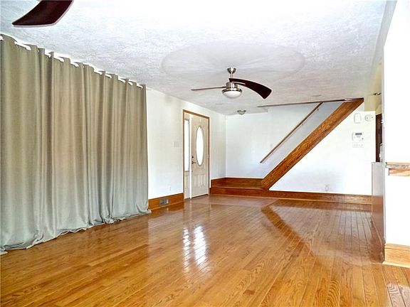 Huge Living Room with massive picture window, 2 ceiling fans and custom Oak flooring.