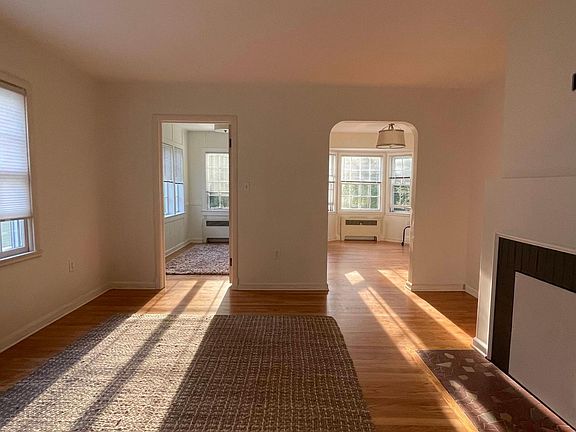 Living area in natural light with hardwood floors and large windows