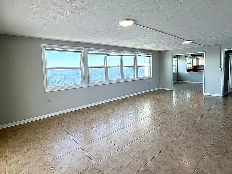 Spacious apartment with large windows offering stunning waterfront views and abundant natural light.